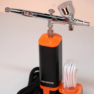 Draufsicht auf ein kabelloses Airbrush-Set mit Mikrokompressor und Akku