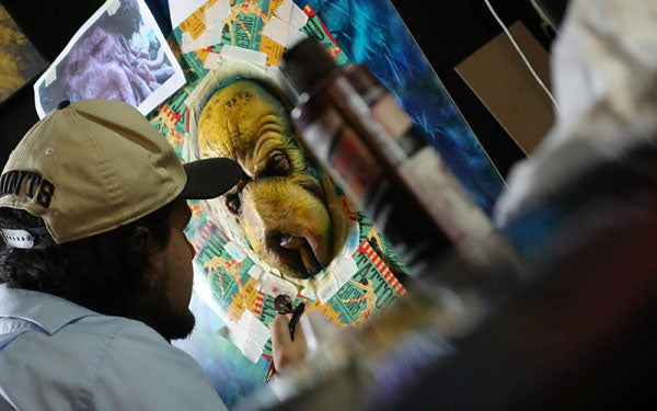 alex germany airbrush artist is painting on a canvas with airbrush