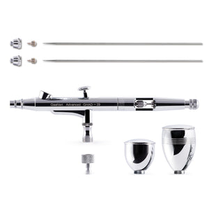 A chrome airbrush kit with interchangeable needles, nozzles, and cups, shown disassembled and laid out on a white background.